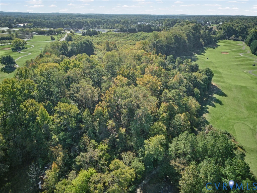 Expansive wooded lot featuring mature trees and bordering a golf course