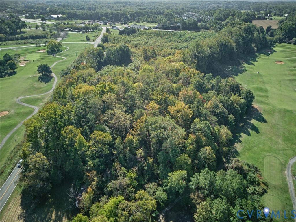Expansive wooded acreage featuring mature trees and direct access to adjacent golf course fairways