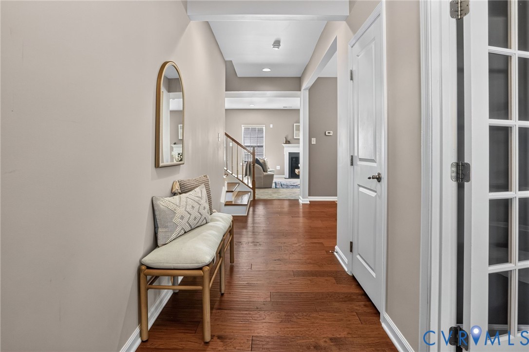 Hallway featuring wood-finish flooring, recessed lighting, and a multi-pane glass-panel door Hallway featuring wood-finish flooring, recessed lighting, and a multi-pane glass-panel door