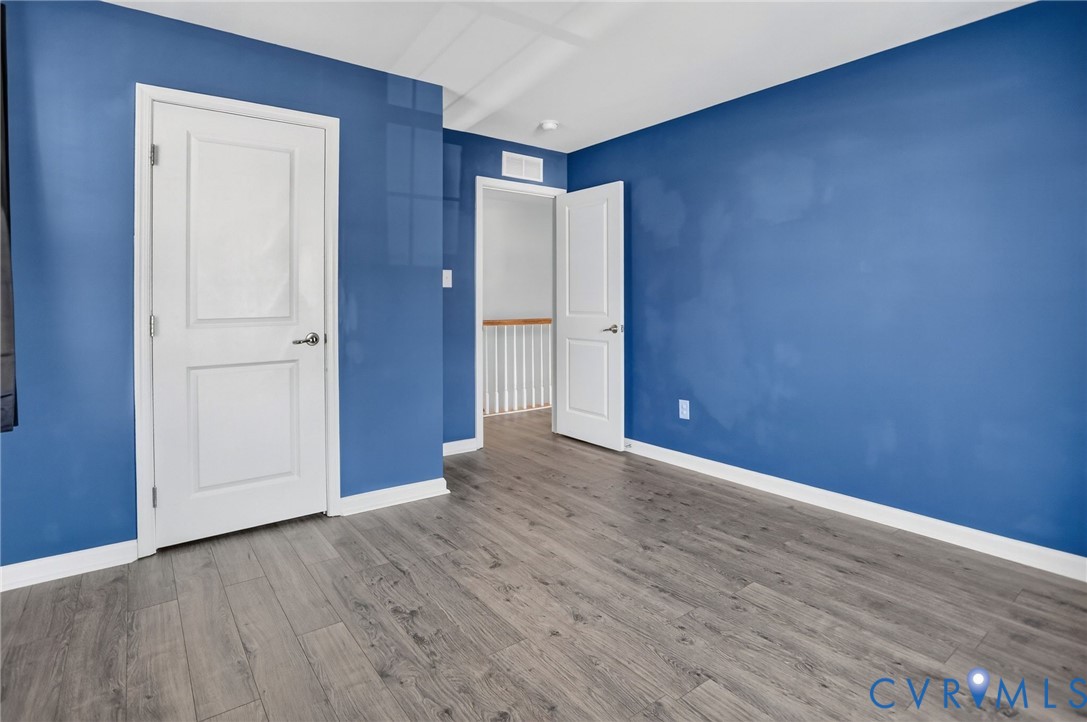 Room featuring wood-finish flooring and two-panel interior doors with brushed nickel hardware