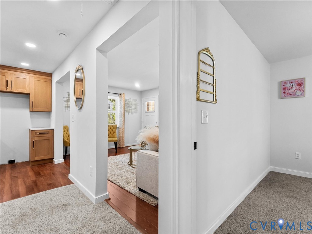 Interior space featuring wood-finish flooring, recessed lighting, and wooden cabinetry with hardware