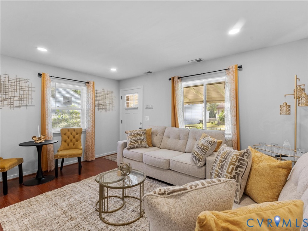Living area featuring wood-finish flooring, recessed lighting, and dual windows