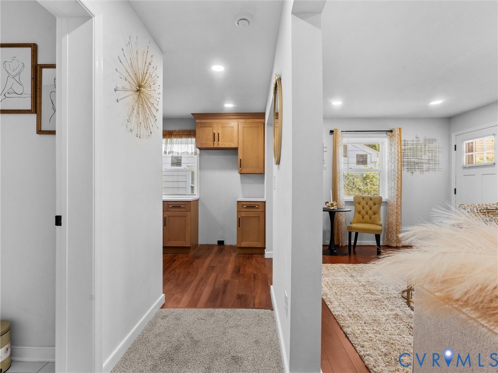 Interior space featuring wood-finish flooring, recessed lighting, and wooden cabinetry with hardware