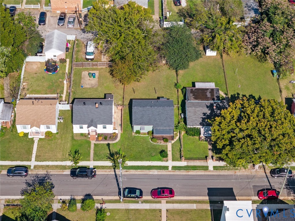 Aerial perspective showing residential lots with mature trees, established grass lawns, and concrete sidewalk access