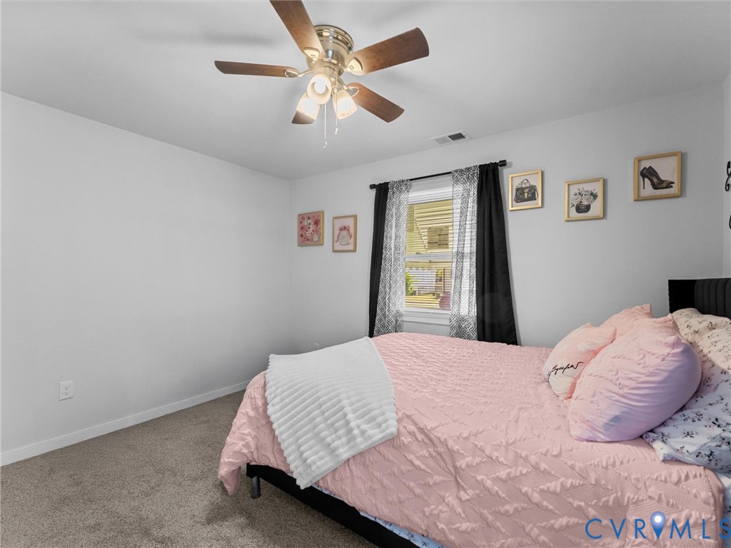 Room featuring neutral wall-to-wall carpeting, a ceiling fan with integrated lighting, and a window with neutral wall finishes