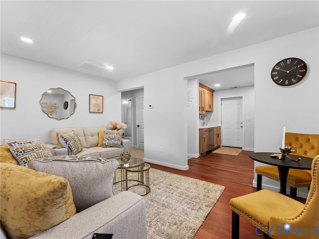 Open-concept interior featuring wood-finish flooring, recessed lighting, and built-in cabinetry with hardware