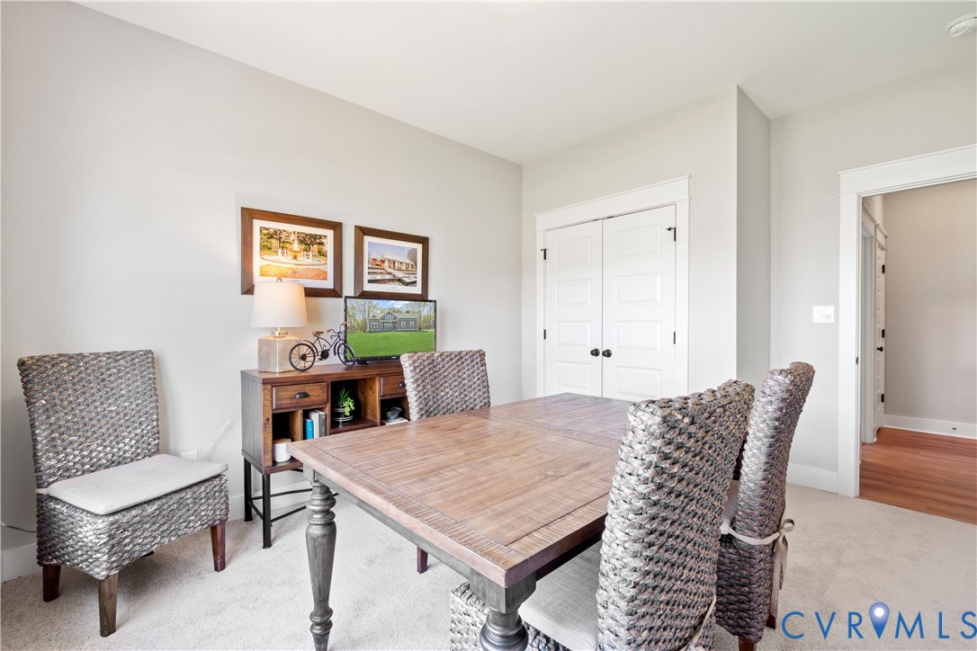 Neutral-toned interior featuring neutral wall-to-wall carpeting, high ceilings, and double-panel doors with matte black hardware