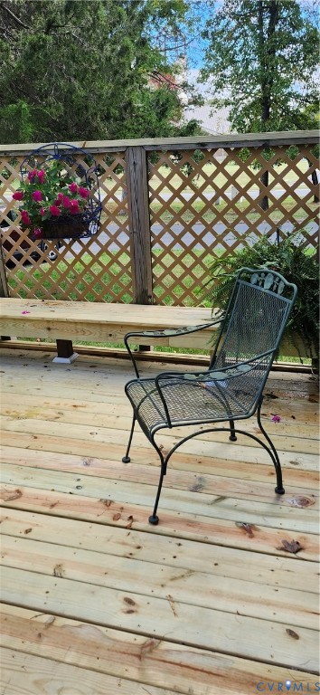 Outdoor deck featuring wood-plank flooring, an integrated wood bench, and a lattice privacy screen
