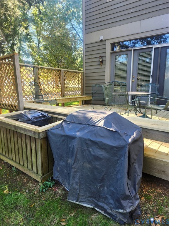 Wood-plank exterior siding featuring a multi-level deck with wooden lattice privacy screening and built-in bench seating, complete with glass-paned double doors