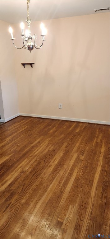 Wood-finish flooring, multi-arm metal chandelier, and wall-mounted shelving