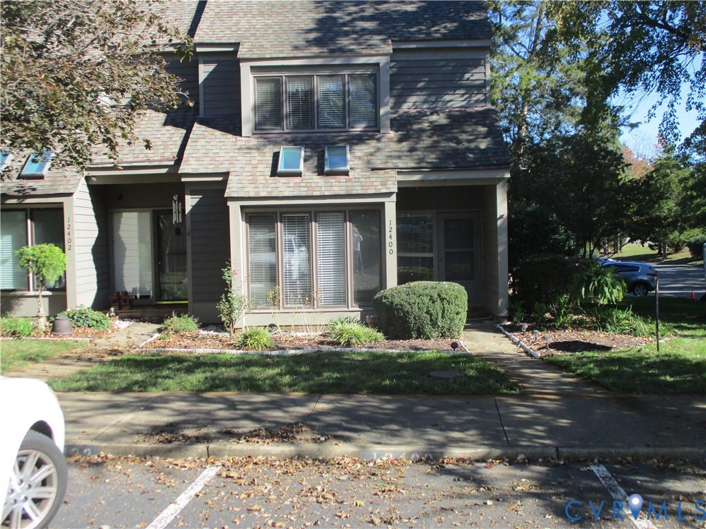 Multi-level exterior featuring horizontal lap siding, a shingled roof, dual skylights, bay windows, and a concrete front walkway Multi-level exterior featuring horizontal lap siding, a shingled roof, dual skylights, bay windows, and a concrete front walkway