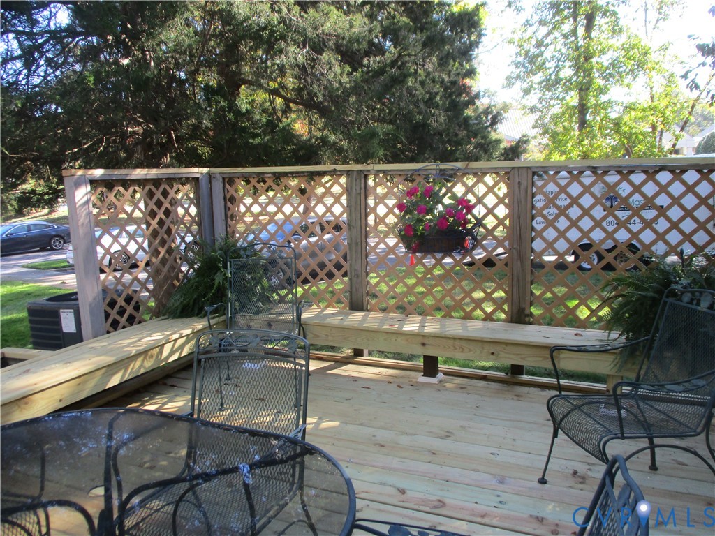 Wood deck featuring integrated bench seating and a perimeter lattice privacy screen