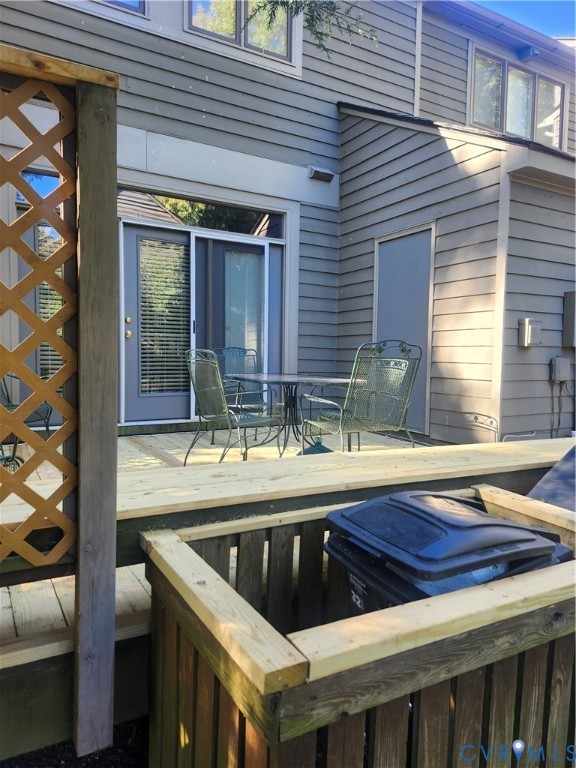 Exterior wood deck featuring horizontal lap siding, wood lattice privacy screen, and an integrated wood enclosure