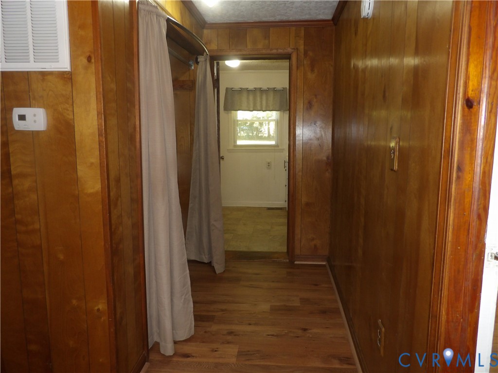 Wood-panelled interior walls, wood-finish flooring, and a built-in recessed storage area