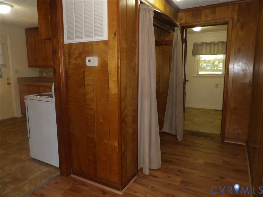 Interior space featuring wood-paneled walls, wood-finish flooring, and built-in closet storage