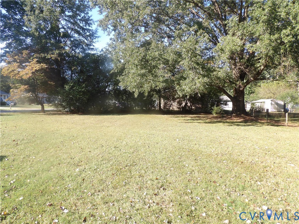 Expansive level lot featuring mature hardwood trees and established landscaping