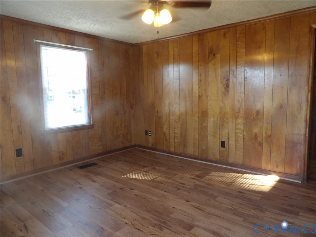 Wood-paneled wall finishes, wood-finish flooring, and a central ceiling-mounted light fixture