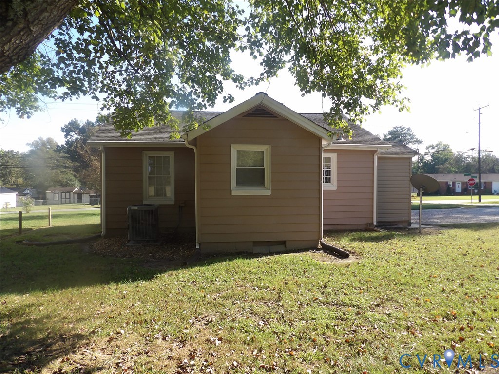 Exterior elevation featuring horizontal siding, a gabled roofline, multi-pane windows, and a mature tree canopy