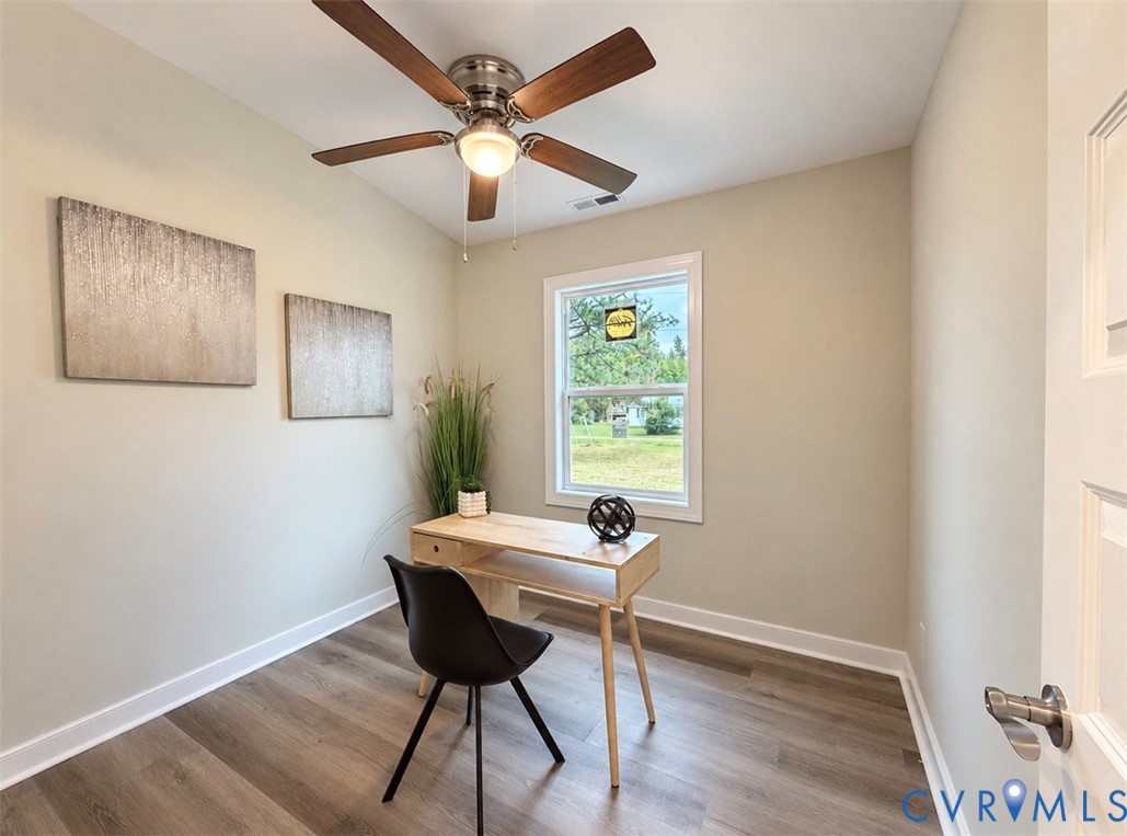 Room featuring wood-finish flooring, a multi-blade ceiling fan with integrated lighting, and a single-hung window with white casing