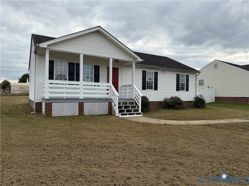Vinyl siding exterior featuring a covered front porch, brick foundation accent, shutter-clad windows, and a paved walkway Vinyl siding exterior featuring a covered front porch, brick foundation accent, shutter-clad windows, and a paved walkway