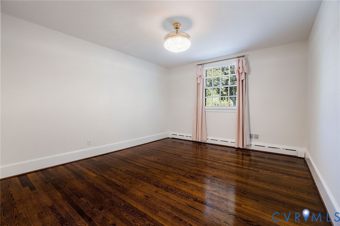 Bedroom 3 with hardwoods, ceiling fan, window treatments and closet system.