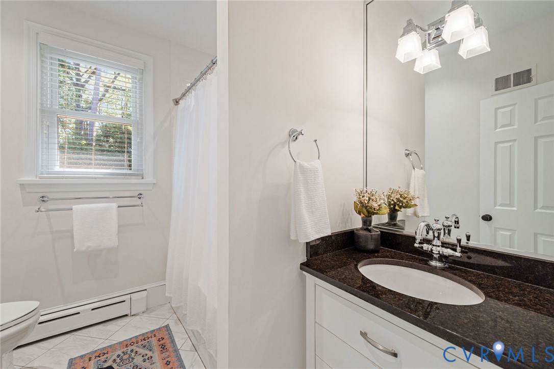 Full hall bathroom with timeless finishes for Bedrooms 2 and 3.
