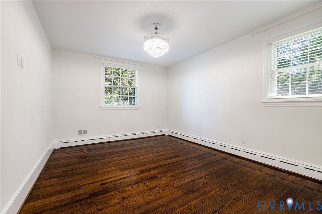 Bedroom 2 with hardwoods, ceiling fan, window treatments and closet system.
