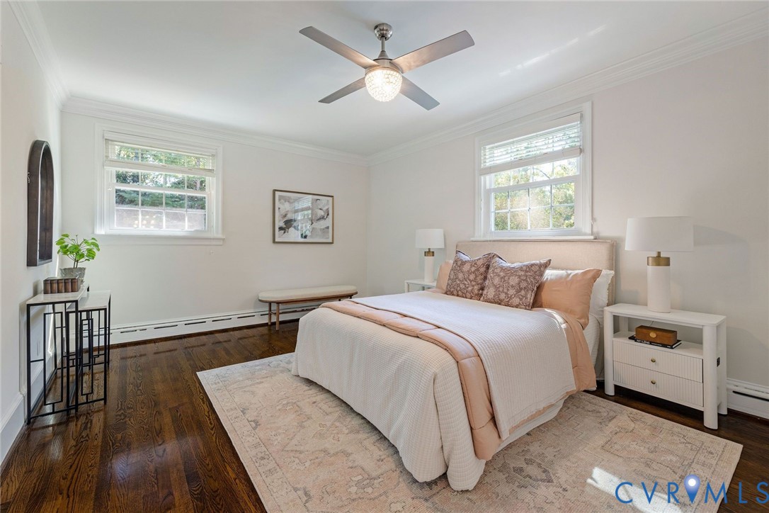 First floor primary with fresh palette, hardwoods and ceiling fan.
