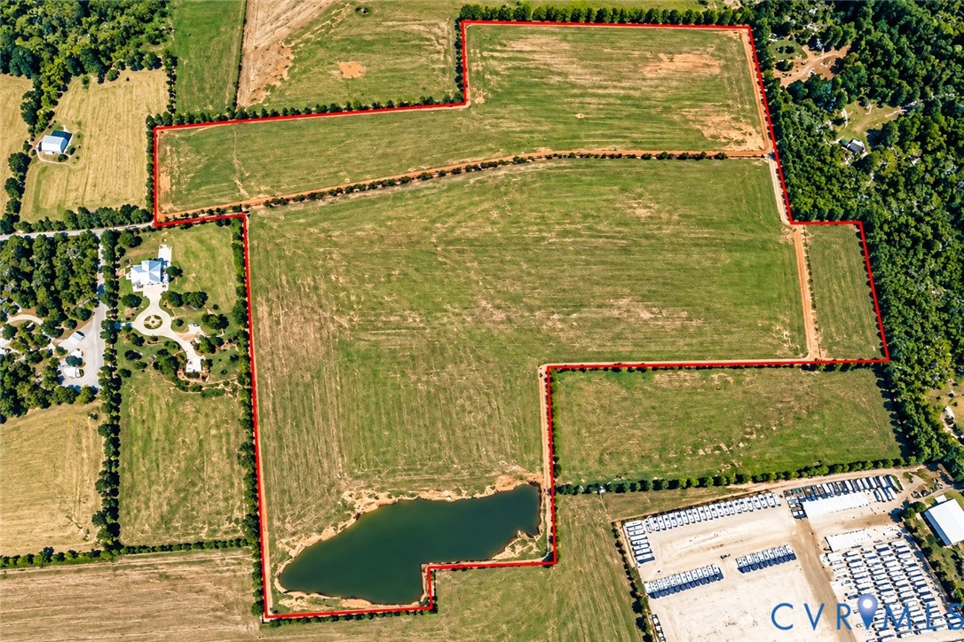 Expansive acreage featuring cleared pasture land, established perimeter tree lines, and a dedicated pond