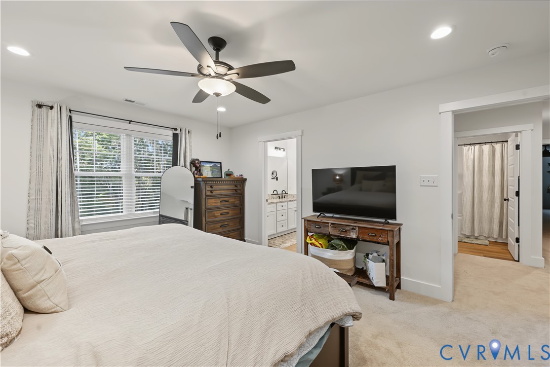 Bedroom featuring neutral wall paint, carpeted flooring, a multi-blade ceiling fan with integrated lighting, and recessed ceiling lighting