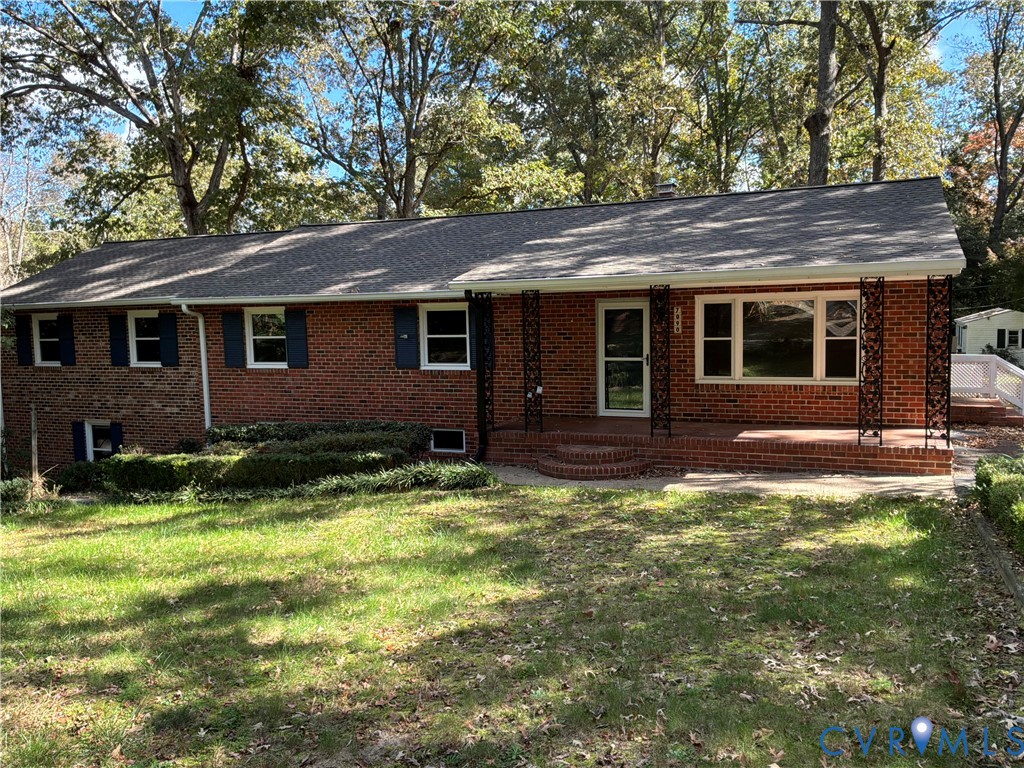Traditional brick exterior featuring decorative wrought iron porch supports, covered brick front porch, and mature surrounding landscape Traditional brick exterior featuring decorative wrought iron porch supports, covered brick front porch, and mature surrounding landscape