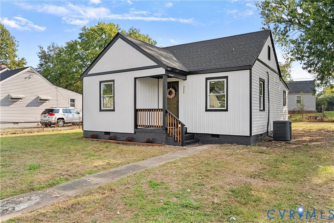 Exterior featuring vertical board-and-batten siding, contrasting dark trim, a covered front porch with wood railing, and a gabled roofline Exterior featuring vertical board-and-batten siding, contrasting dark trim, a covered front porch with wood railing, and a gabled roofline