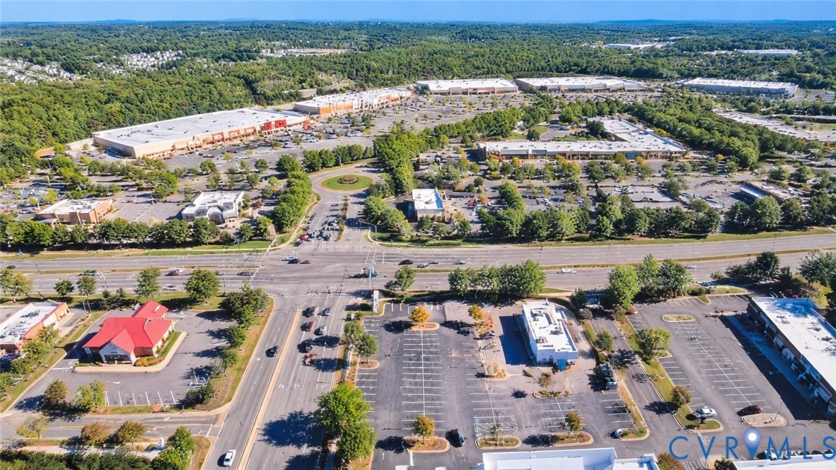 Aerial view of a commercial district featuring paved parking lots, multi-tenant retail structures, professional office buildings, and integrated landscaping