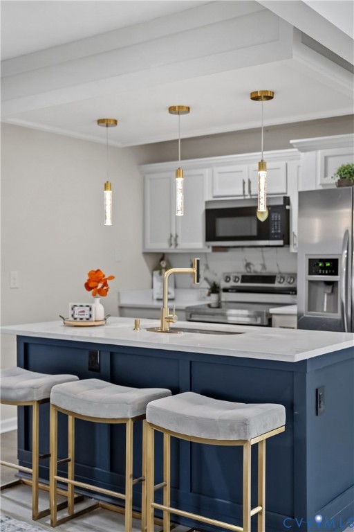 Kitchen island featuring a navy blue cabinet base, quartz countertop, and gold-finish hardware Kitchen island featuring a navy blue cabinet base, quartz countertop, and gold-finish hardware