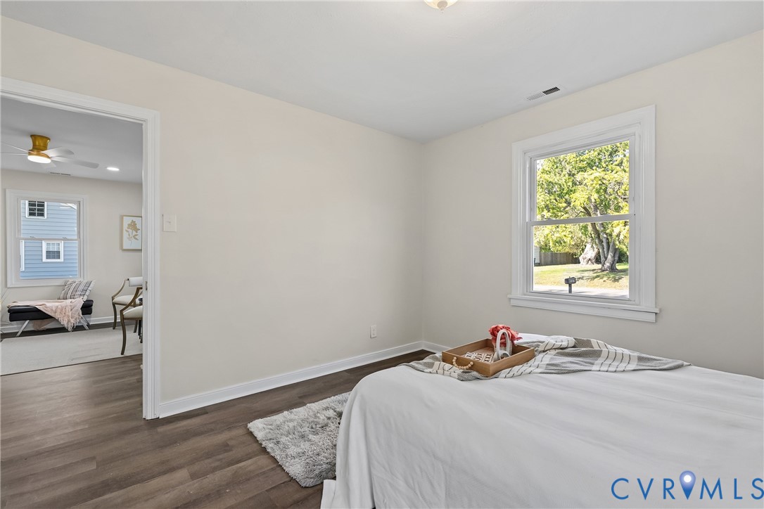Neutral-toned interior featuring wood-finish flooring, white window trim, and a double-hung window