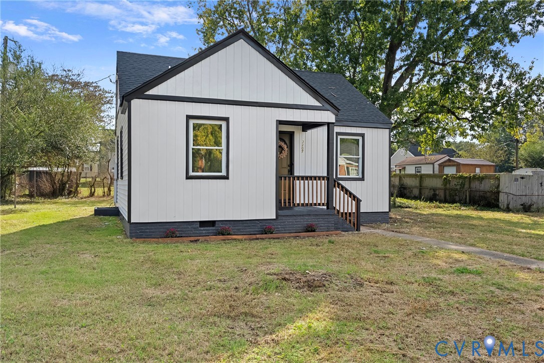 Board-and-batten exterior with contrasting trim, asphalt shingle roof, covered front porch, and concrete walkway Board-and-batten exterior with contrasting trim, asphalt shingle roof, covered front porch, and concrete walkway