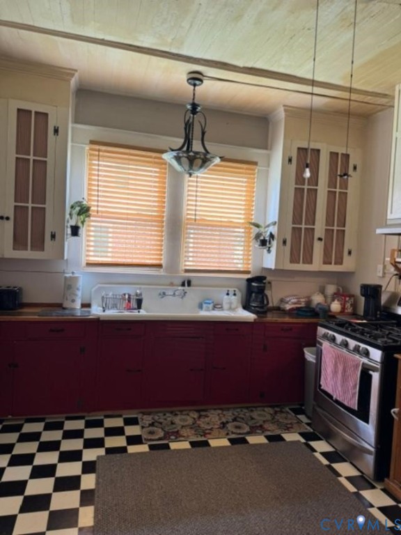 Kitchen featuring cabinetry with paneled upper doors, high-back apron-front sink, tongue-and-groove ceiling paneling, and checkered tile flooring Kitchen featuring cabinetry with paneled upper doors, high-back apron-front sink, tongue-and-groove ceiling paneling, and checkered tile flooring