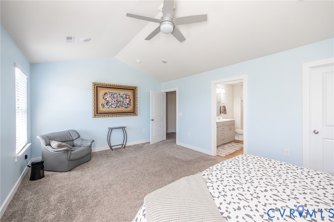 Vaulted ceiling featuring a central light-integrated ceiling fan, neutral wall-to-wall carpeting, and multiple interior doors Vaulted ceiling featuring a central light-integrated ceiling fan, neutral wall-to-wall carpeting, and multiple interior doors