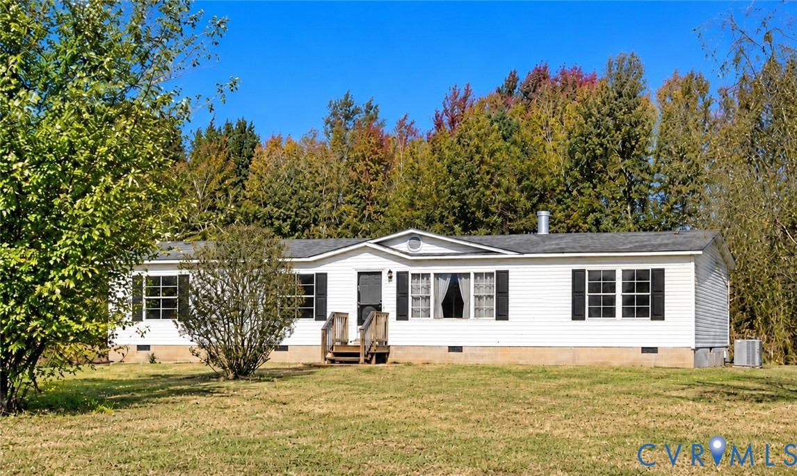 Single-story exterior featuring white horizontal siding, dark window shutters, a peaked roofline, and wood-step entry Single-story exterior featuring white horizontal siding, dark window shutters, a peaked roofline, and wood-step entry