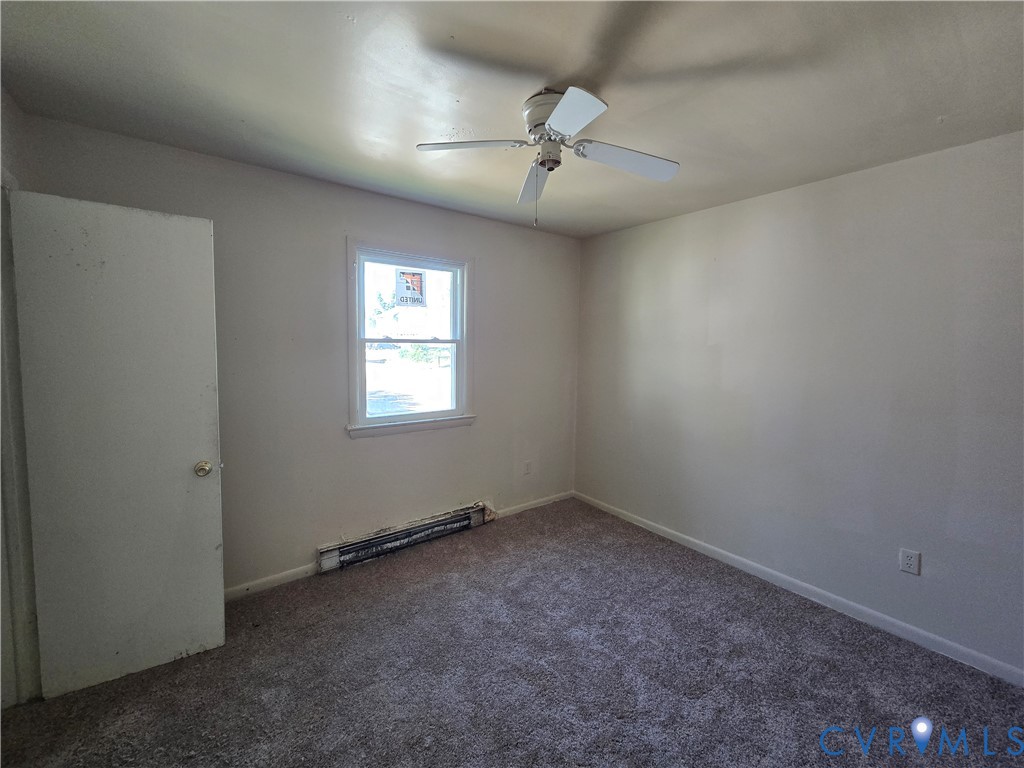 Room featuring neutral carpeting, a ceiling fan, and a single-pane window with a white frame Room featuring neutral carpeting, a ceiling fan, and a single-pane window with a white frame