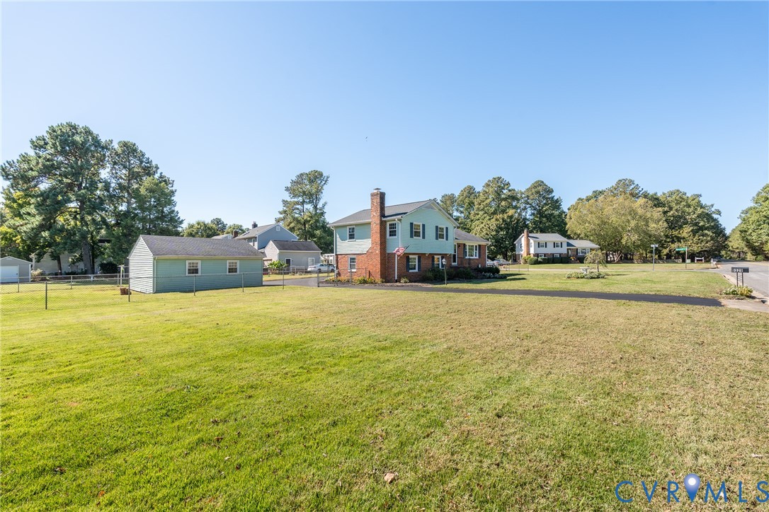 Two-story residence with brick and siding exterior, expansive lawn, asphalt driveway, and detached storage structure Two-story residence with brick and siding exterior, expansive lawn, asphalt driveway, and detached storage structure