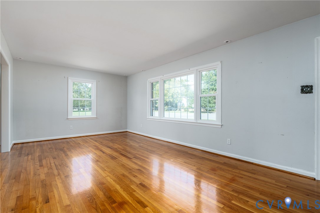 Interior space featuring wood-finish flooring, neutral wall paint, and multi-pane windows