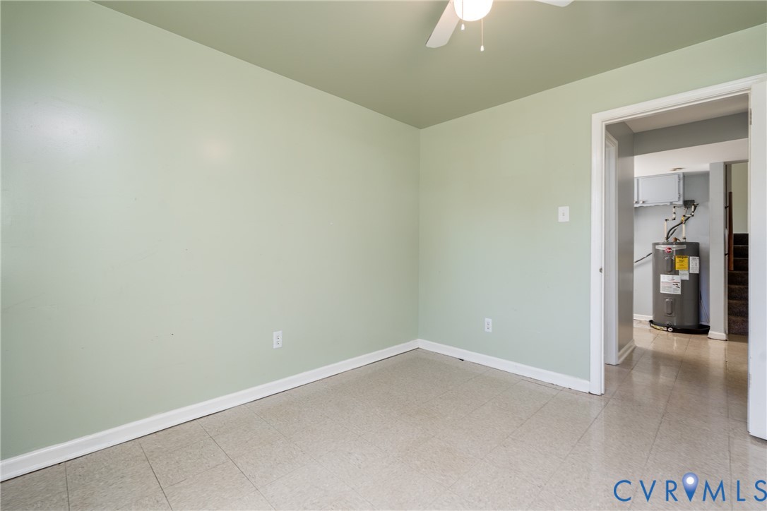 Room featuring neutral-toned tile flooring, ceiling-mounted fan, and light-toned wall finish