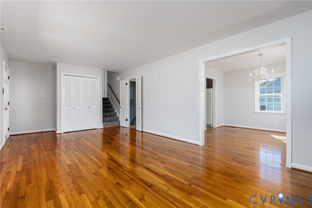 Wood-finish flooring throughout, multi-panel louvered closet doors, carpeted staircase, and decorative crystal chandelier Wood-finish flooring throughout, multi-panel louvered closet doors, carpeted staircase, and decorative crystal chandelier