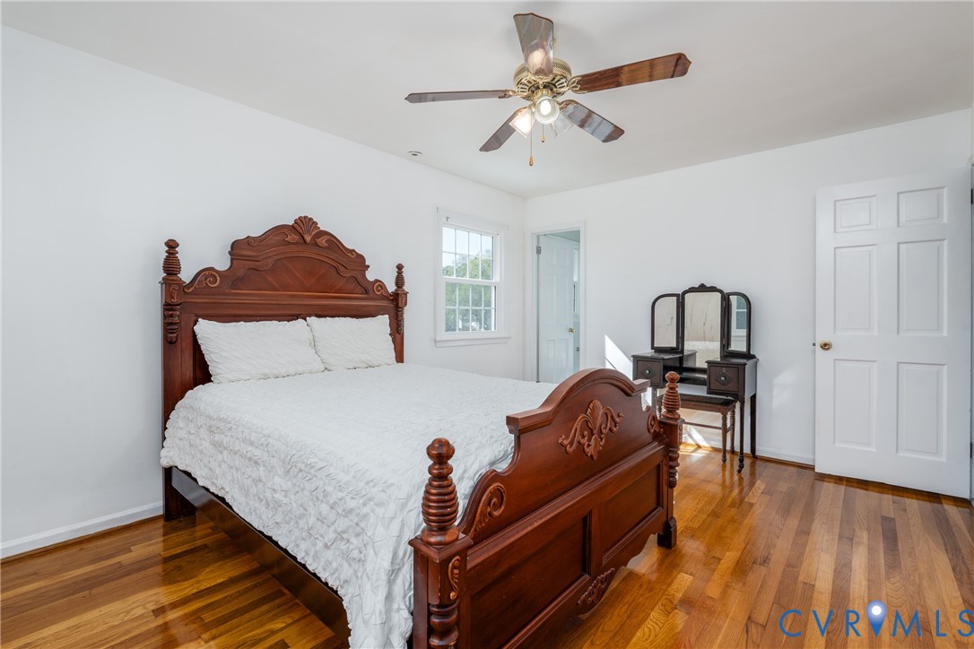 Wood-finish flooring, multi-pane window, and a ceiling fan with integrated light fixture