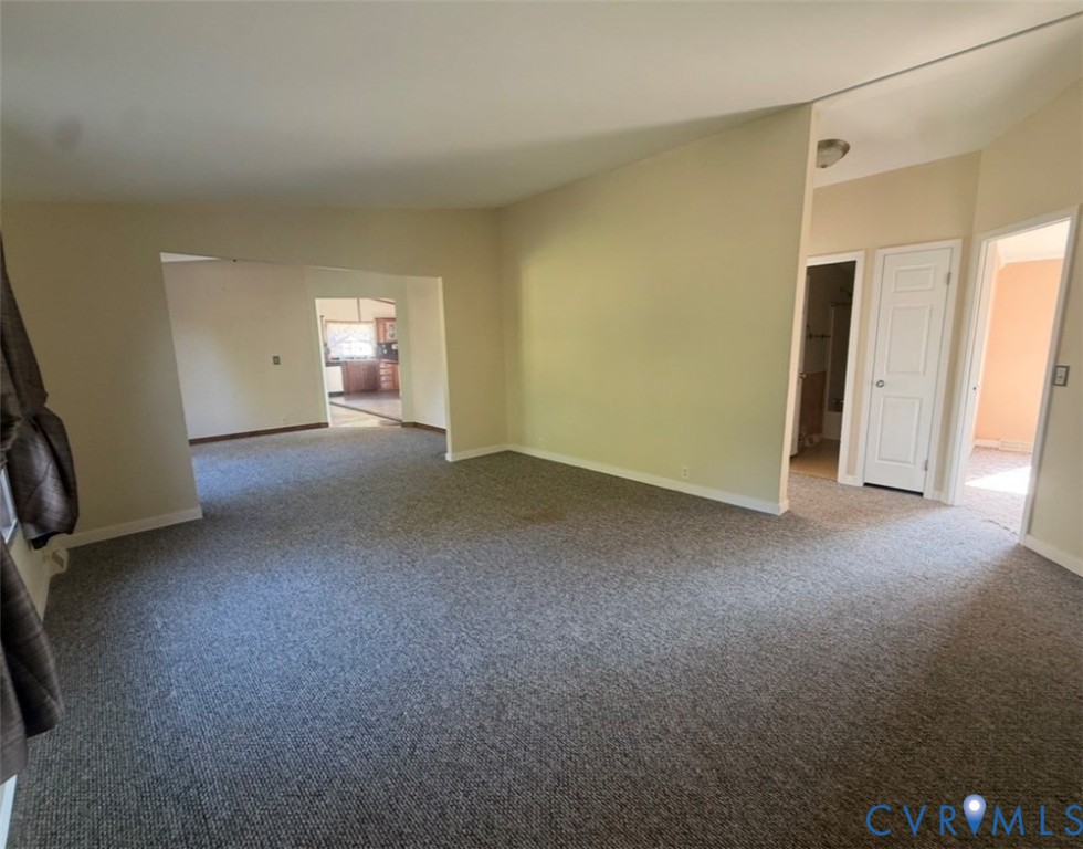 Vaulted ceilings, neutral wall tones, and carpeted flooring