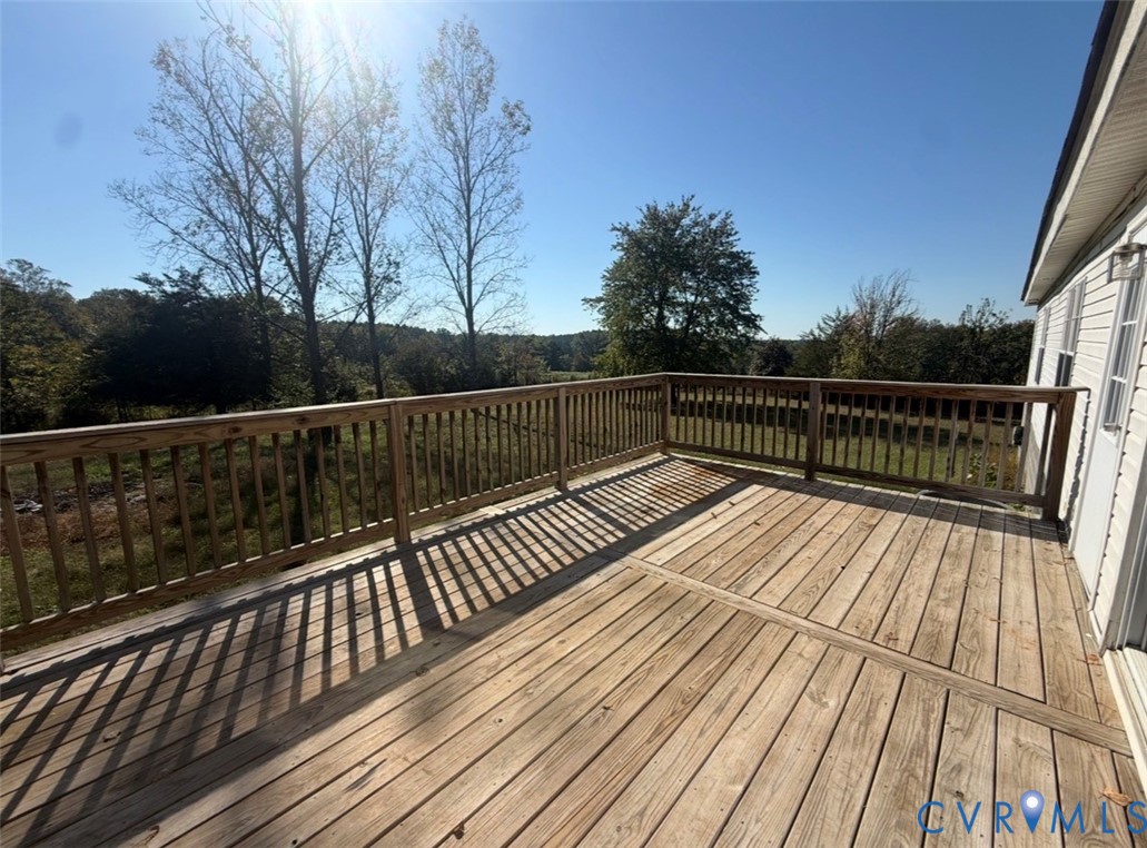 Elevated wood deck featuring vertical baluster railings and expansive natural scenery