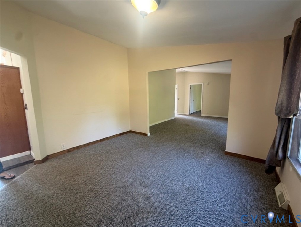 Interior space featuring neutral wall paint, gray carpeting, and a flush-mount ceiling light fixture