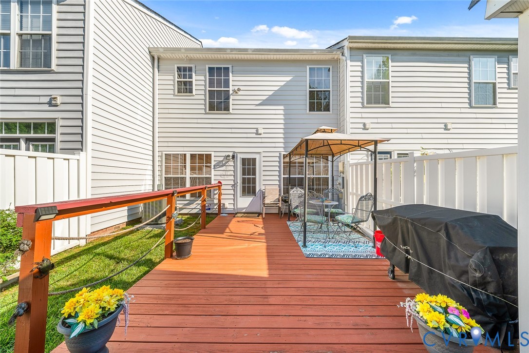Backyard featuring a wood deck, perimeter vinyl fencing, and siding exterior Backyard featuring a wood deck, perimeter vinyl fencing, and siding exterior