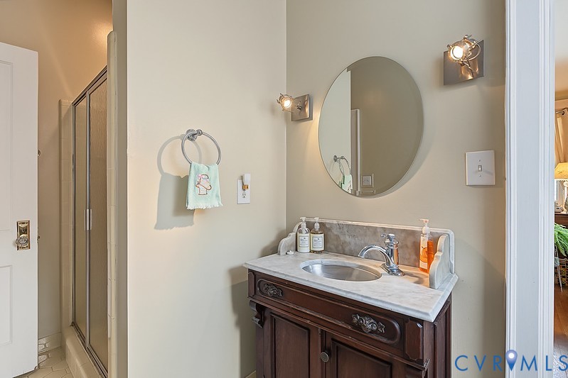 Walk in tiled shower with antique marble basin.
